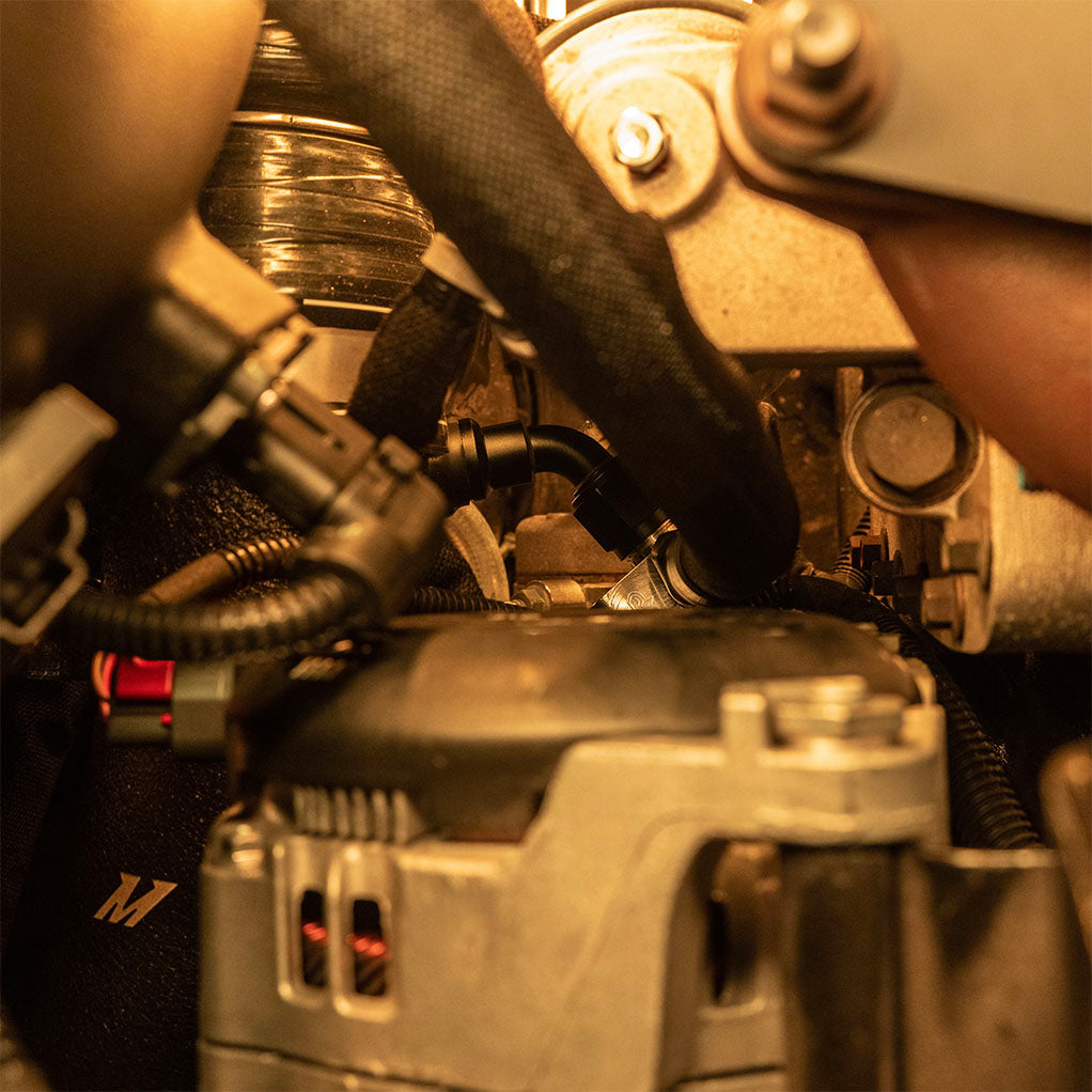 Wide shot of 5th gen cummins billet coolant riser installed with spin on fittings installed.